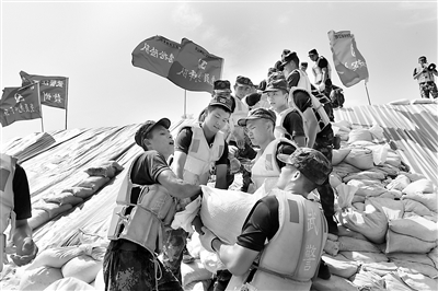 7月以來(lái)，江西多地連降暴雨，九江、上饒、南昌等地遭受嚴(yán)重洪澇災(zāi)害。危急關(guān)頭，武警江西總隊(duì)聞“汛”而動(dòng)，迅速組織官兵全力投入抗洪搶險(xiǎn)戰(zhàn)斗。圖為官兵在九江彭澤縣芙蓉墩圩堤搬運(yùn)沙袋。新華社發(fā)（洪水平 攝）