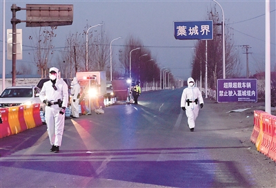 1月5日，在河北省303省道石家莊市藁城區(qū)界疫情檢測點，工作人員對過往車輛進行仔細檢測，同時保證道路正常通行。趙杰 攝