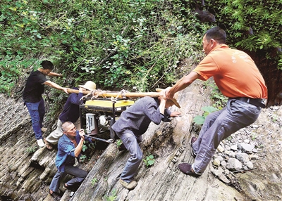 重慶市巫山縣兩坪鄉(xiāng)溪溝村長期季節(jié)性缺水，為切實(shí)解決缺水難題，村干部帶領(lǐng)群眾上山尋水。圖為2020年6月，該村干部群眾抬著百余斤重的發(fā)電機(jī)穿越陡峭的懸崖，把海拔800多米高的山泉水引到村上蓄水池。蘇耀波 攝