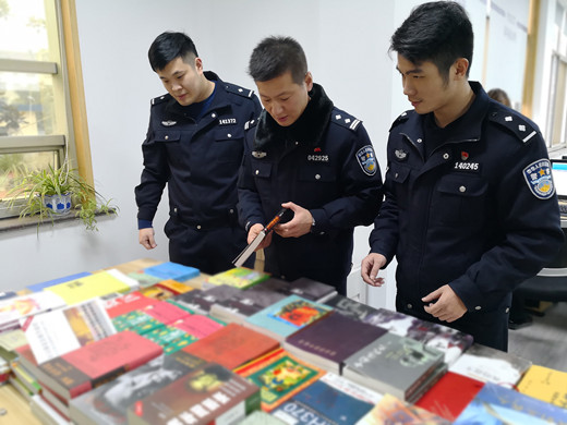 浙江紹興公安辦案人員對(duì)涉案非法出版物樣品和種類進(jìn)行清點(diǎn)整理